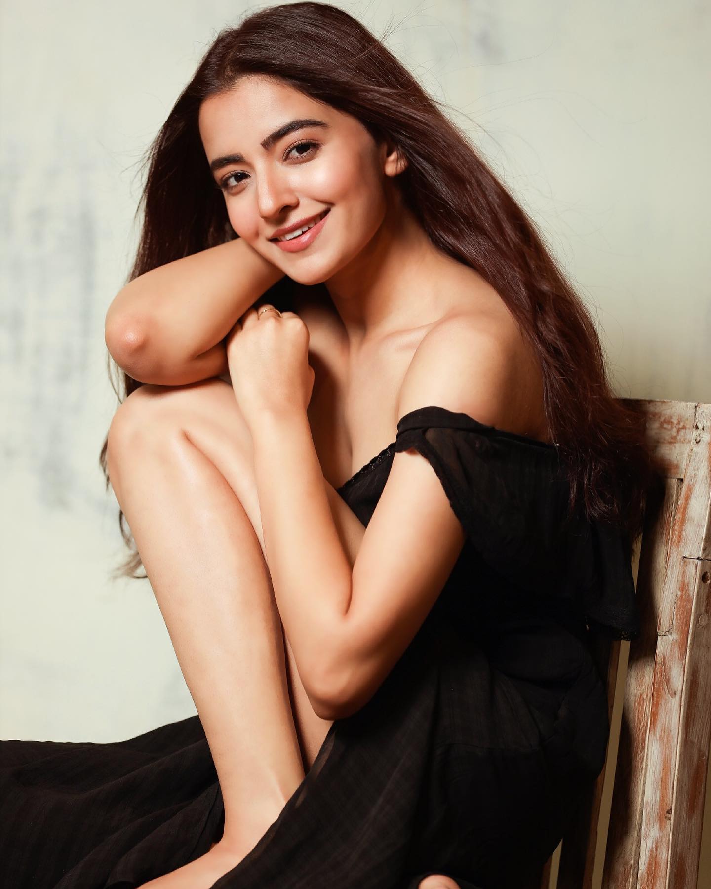 Green car under neon lights in a rainy city street