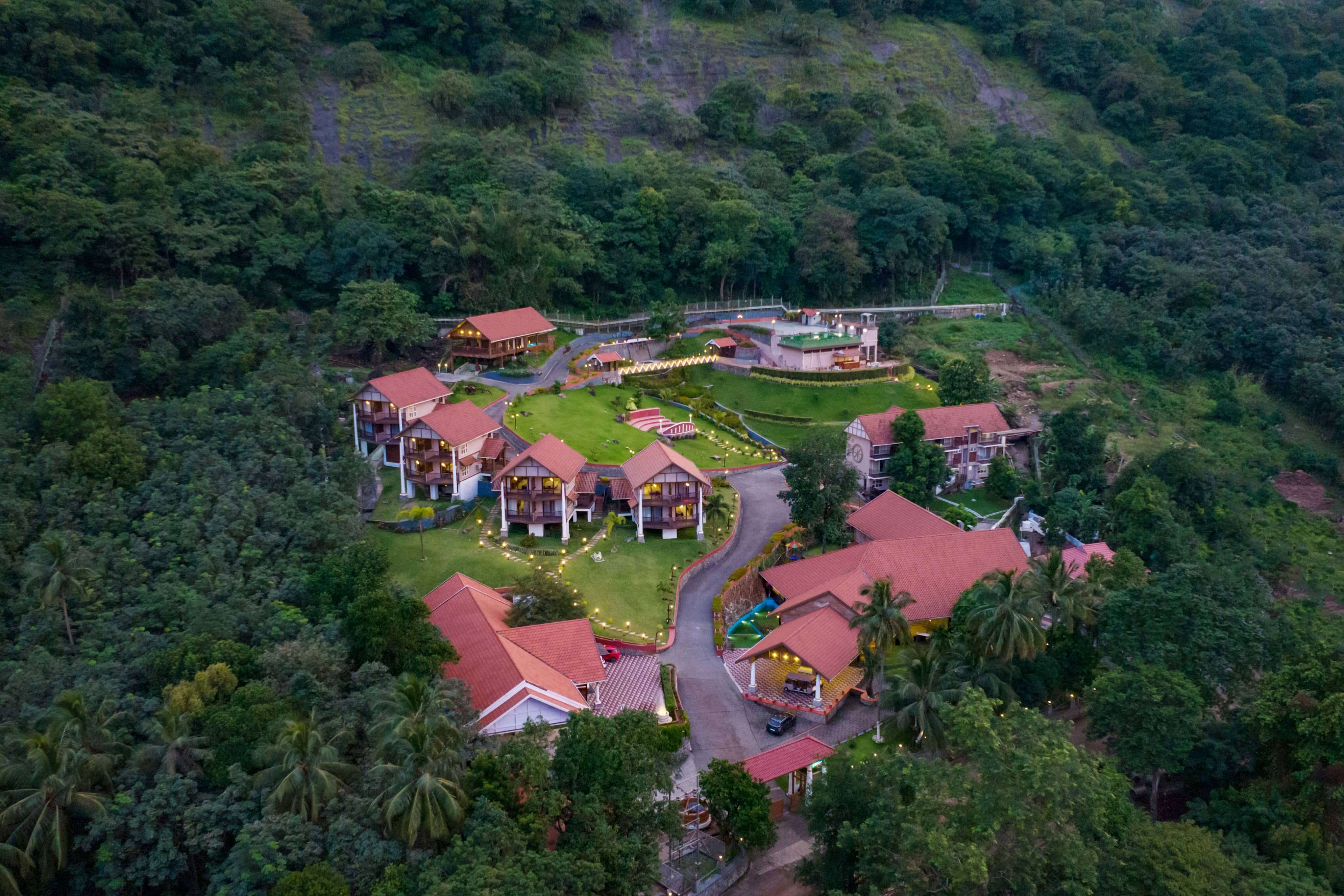 Aerial view of Au Revoir Wellness Resort in Palakkad, Kerala, surrounded by lush greenery and scenic hills. A luxurious non-smoking, non-alcoholic retreat offering Ayurvedic treatments, yoga, and meditation.