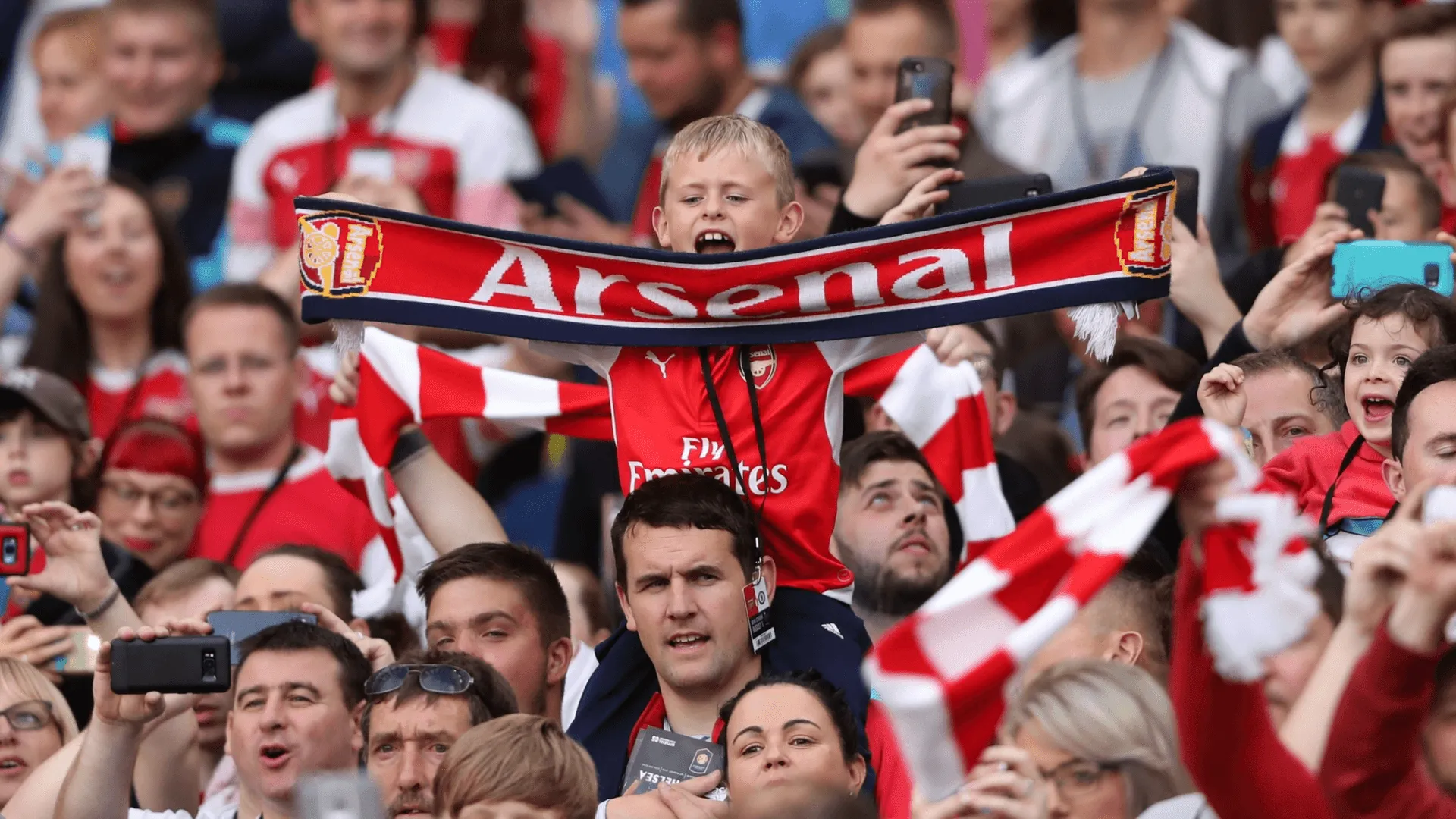 Arsenal fans in the stands watching a game