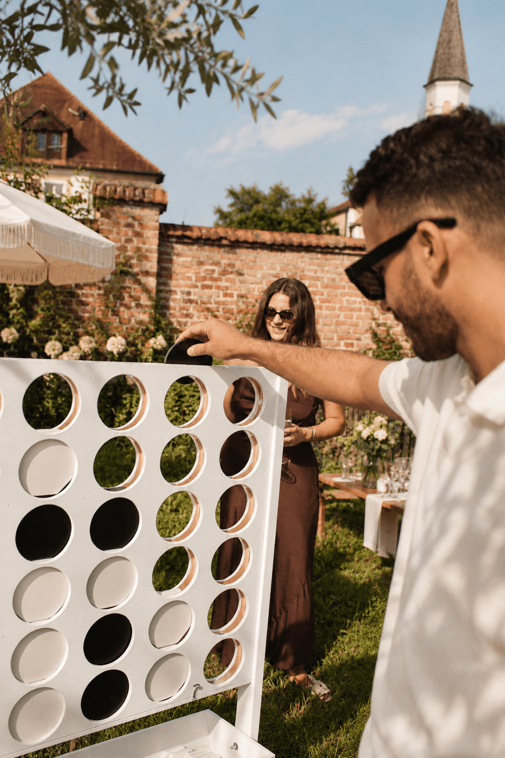 Gäste spielen XXL 4 Gewinnt auf einer Gartenfeier
