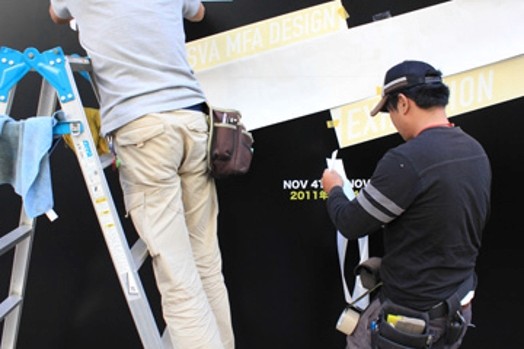 people working on installing stickers on the wall for ideopolis exhibition