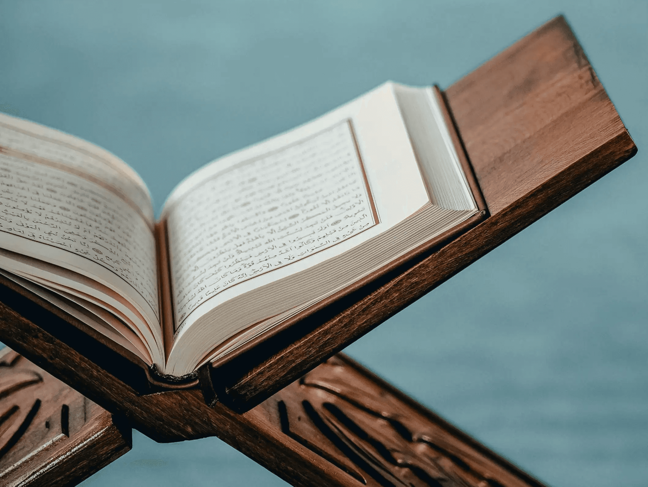 Quran opened on a wooden shelf inside a mosque.