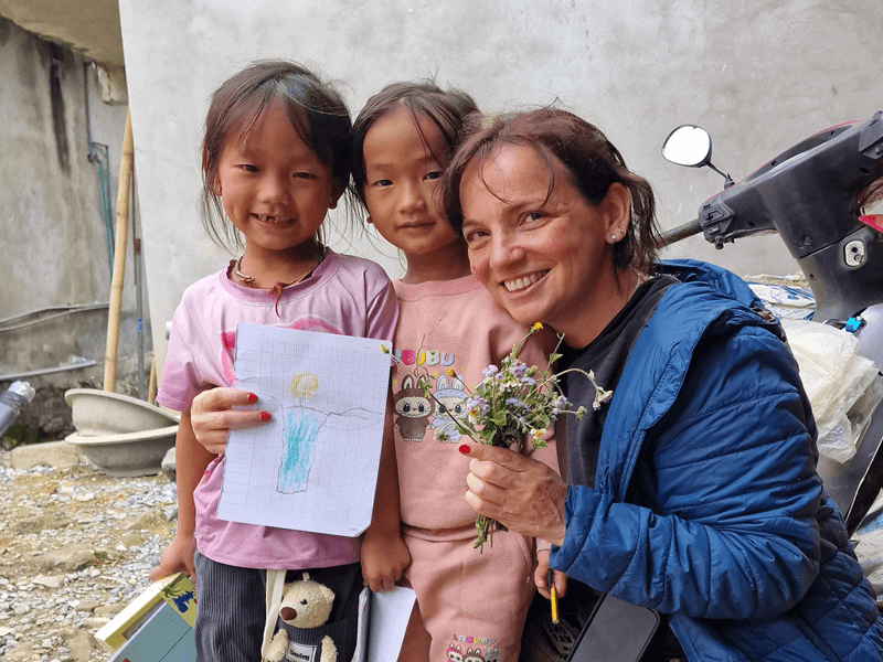 Marcia Rehem com criancás no Vietnam fazendo voluntariado