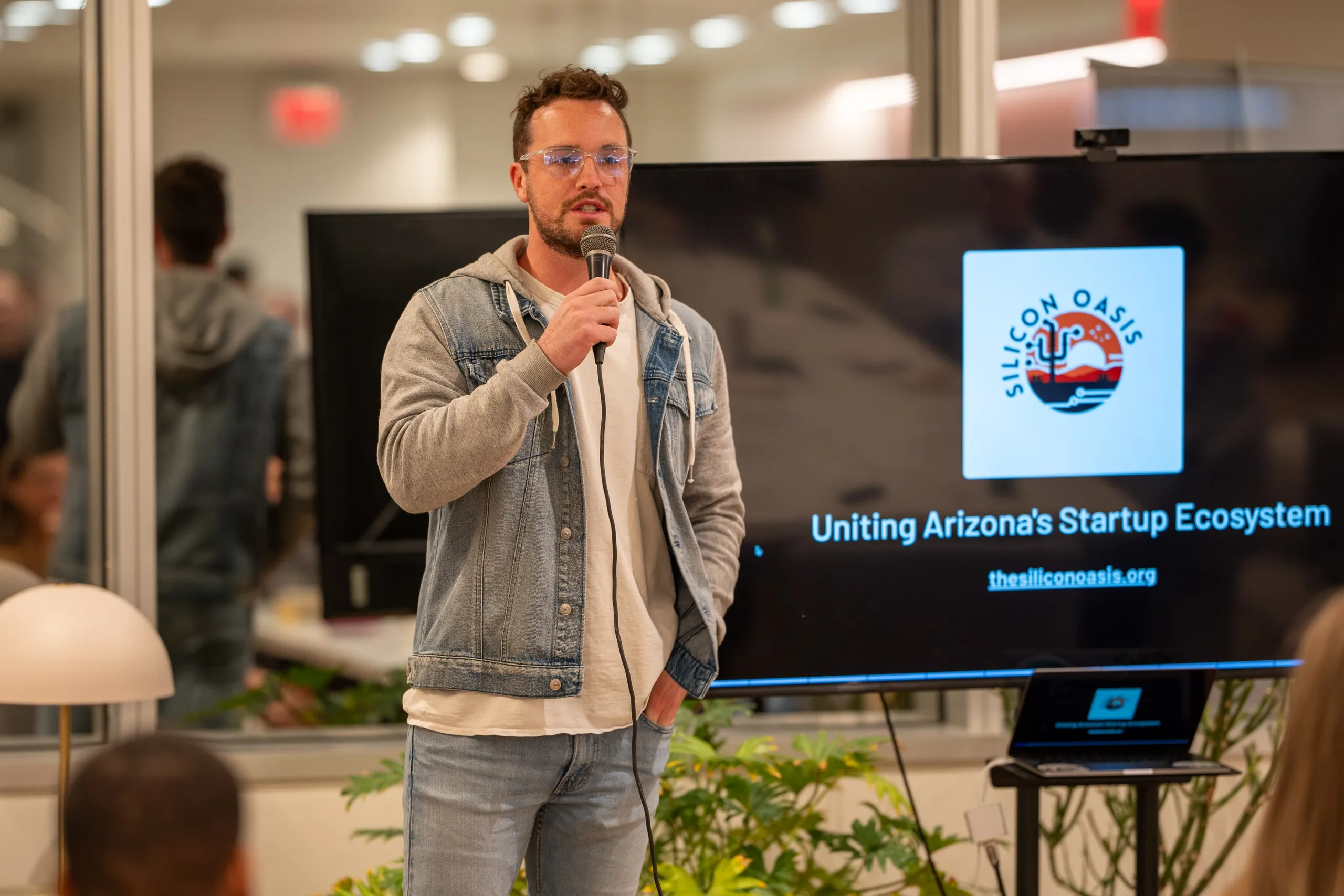 man in black suit jacket holding white ceramic mug