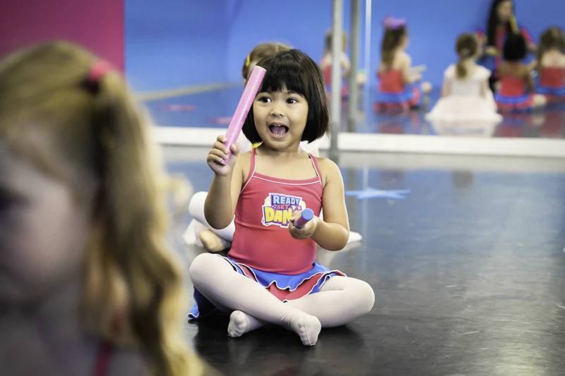 Ready Set Dance student singing in class with rhythm sticks