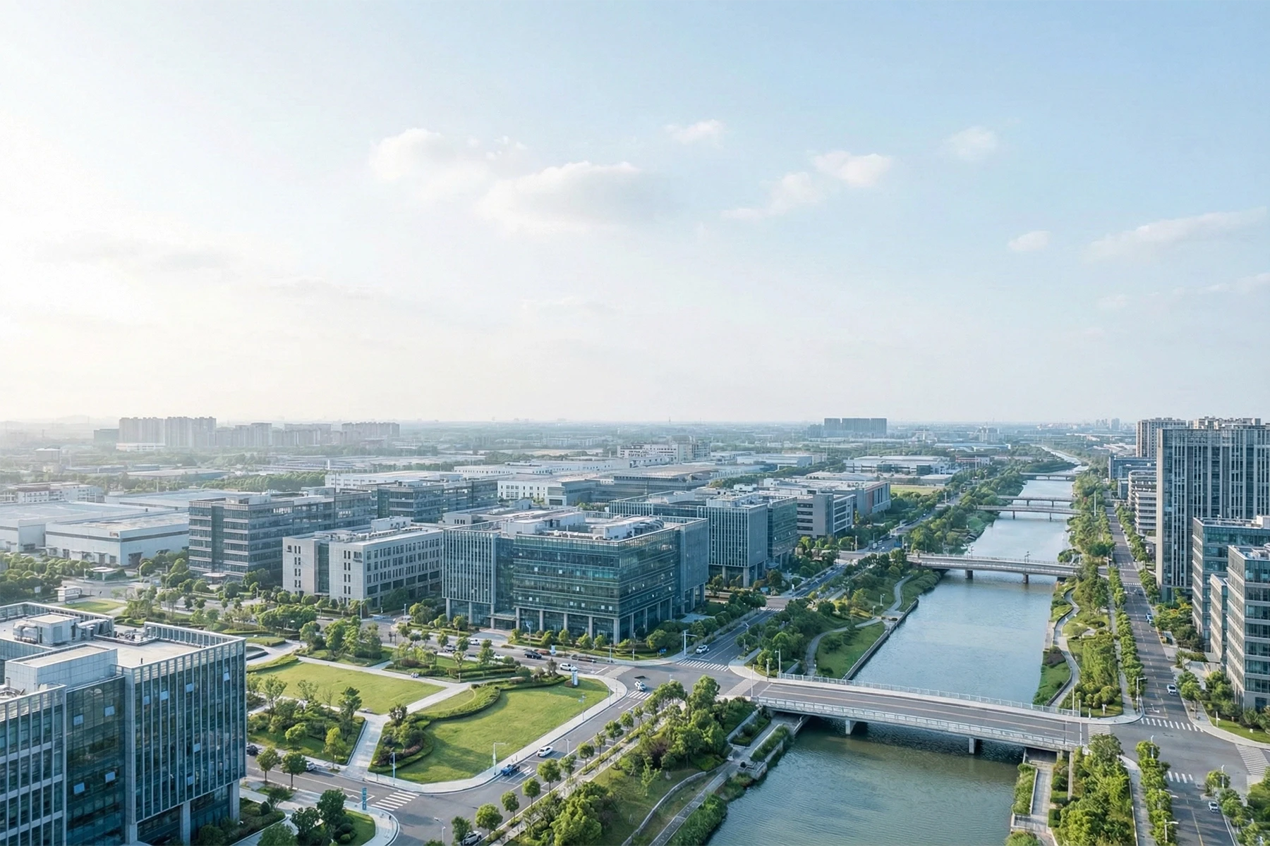 Drohnenaufnahme eines modernen Stadtquartiers mit Bürogebäuden, Grünflächen und Wasserläufen aus der Vogelperspektive – professionelle Luftbilder für Immobilien, Bauprojekte und Imagefilme in Köln und Rhein-Berg.