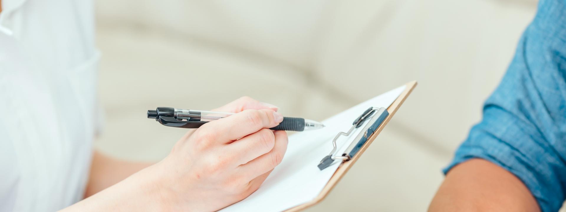 相談中の様子でメモを取る白衣の人物