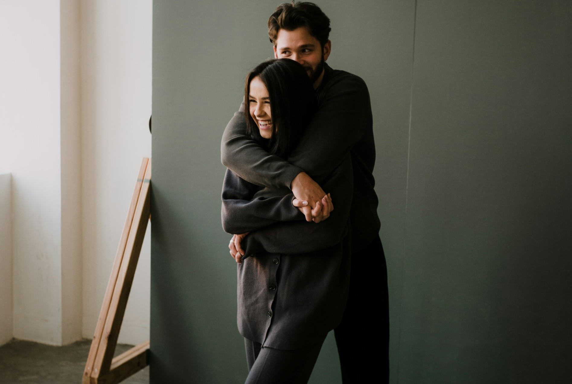 A man hugs a woman from behind