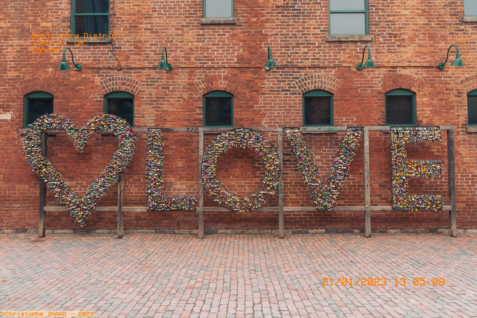 Mur de briques avec l'œuvre "LOVE" faite de cadenas dans le Distillery District.