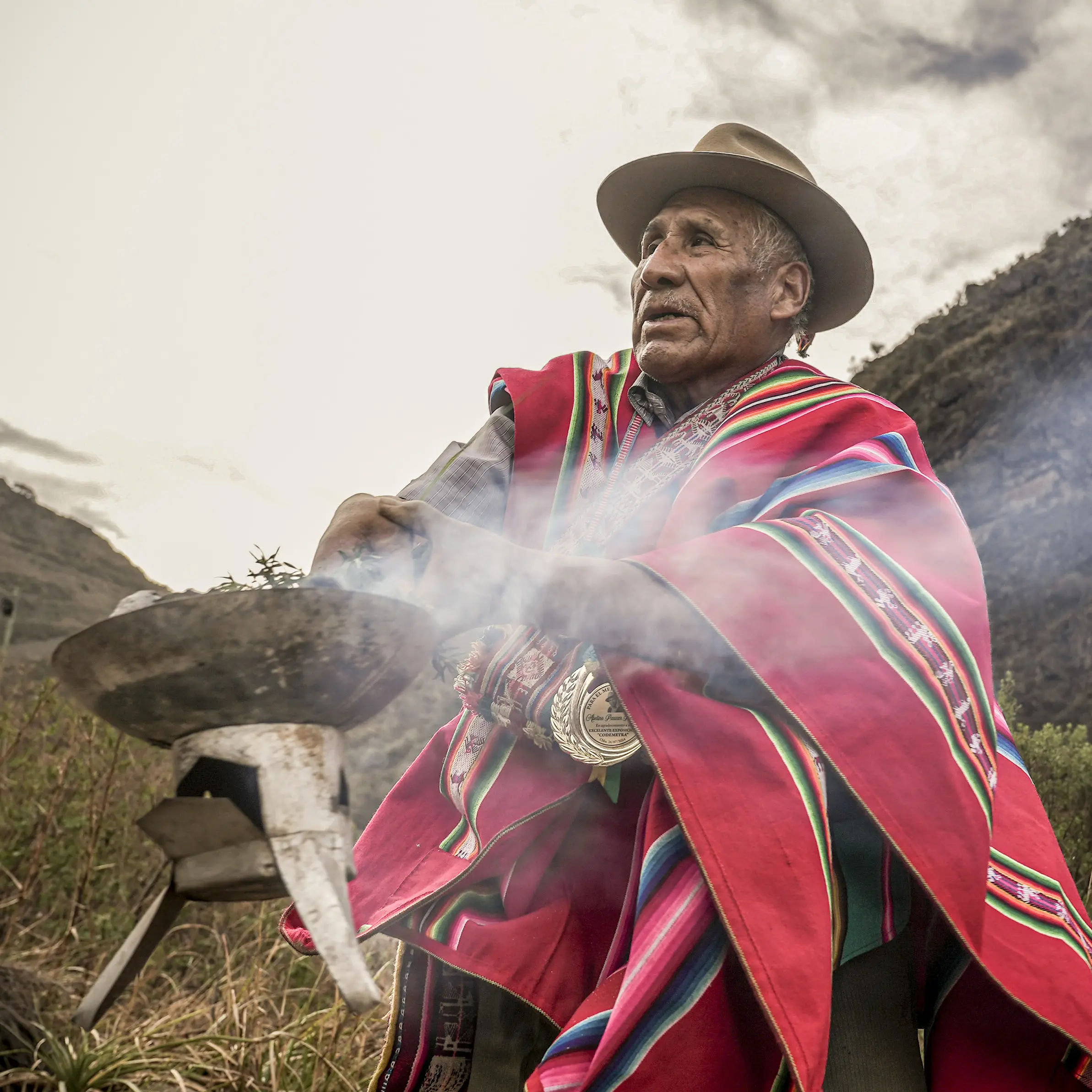 A traditional healer from Bolivia smokes his herbs for the World Health Organization campaign