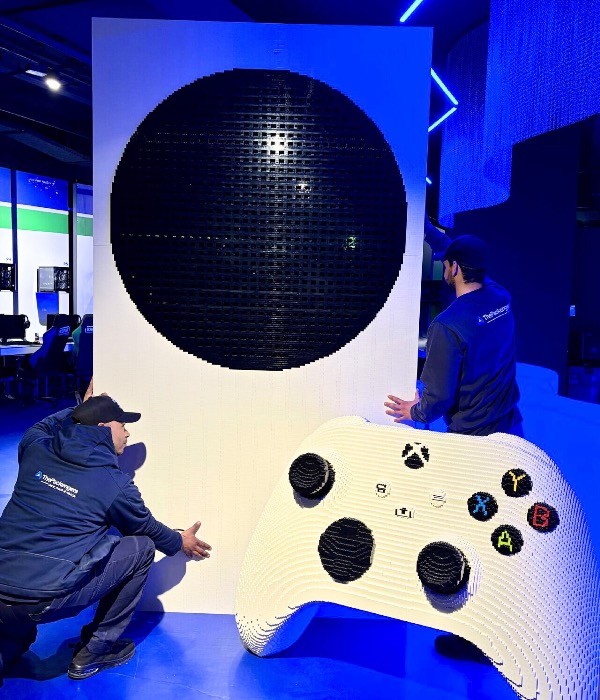 ThePackengers team carefully handling an oversized Xbox controller sculpture, demonstrating specialized logistics for large-scale art installations and promotional items.