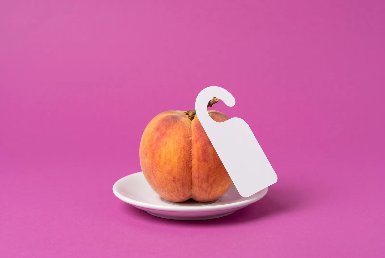 A peach with a blank door hanger on its stem, a playful image for how to block Pornhub on iPhone and iPad