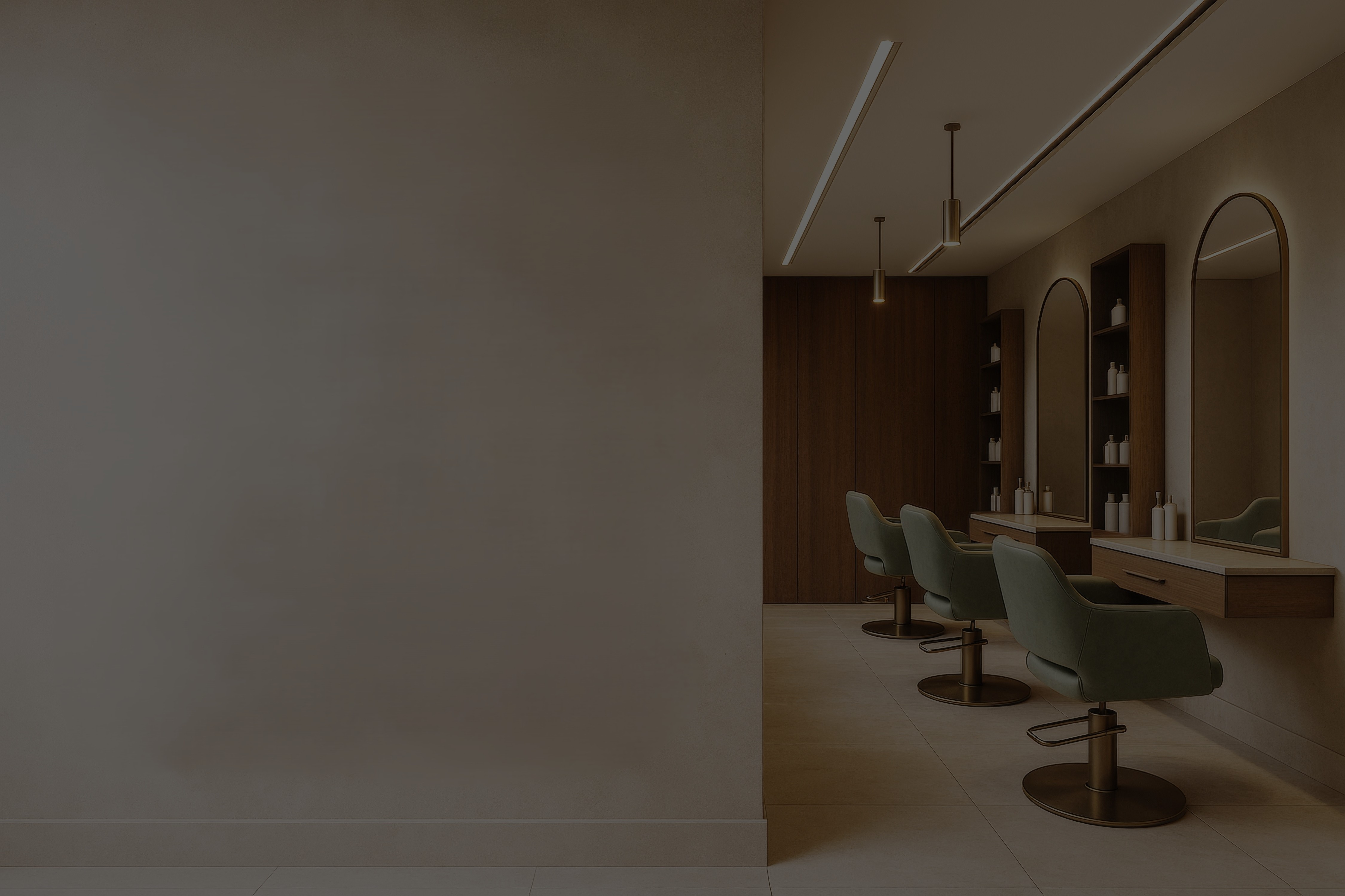 Interior of a modern hair salon with green velvet styling chairs, arched gold mirrors, warm pendant lighting, and wooden shelving with white product bottles