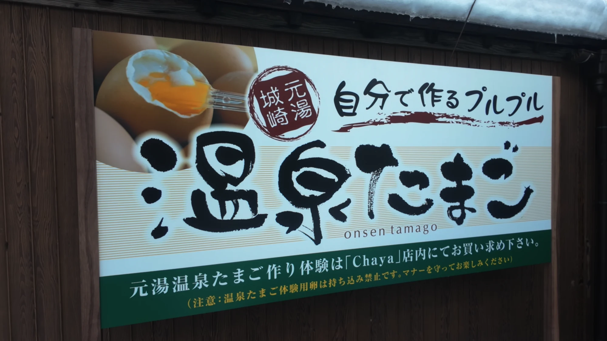 A painted shop sign advertising Kinosaki's onsen tamago, a soft-boiled egg cooked in spring water.