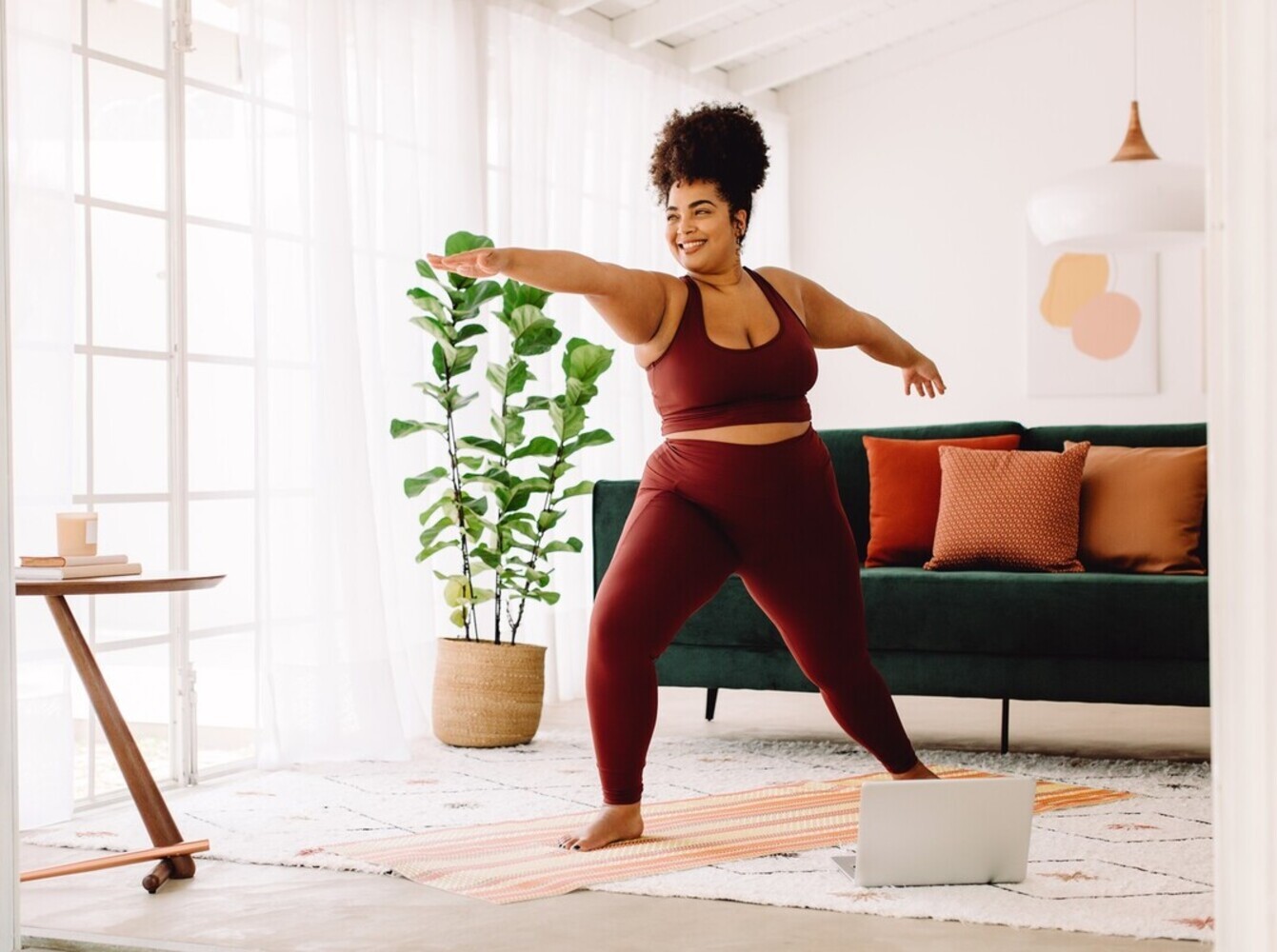 smiling woman showing how to lose weight with yoga by doing a 30-minute routine at home