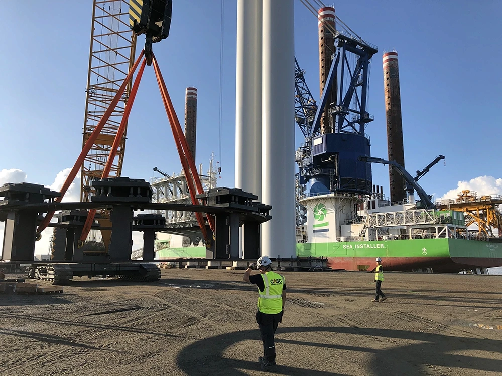 CASC employees guiding the onshore mobilisation of a wind turbine tower using heavy lifting equipment