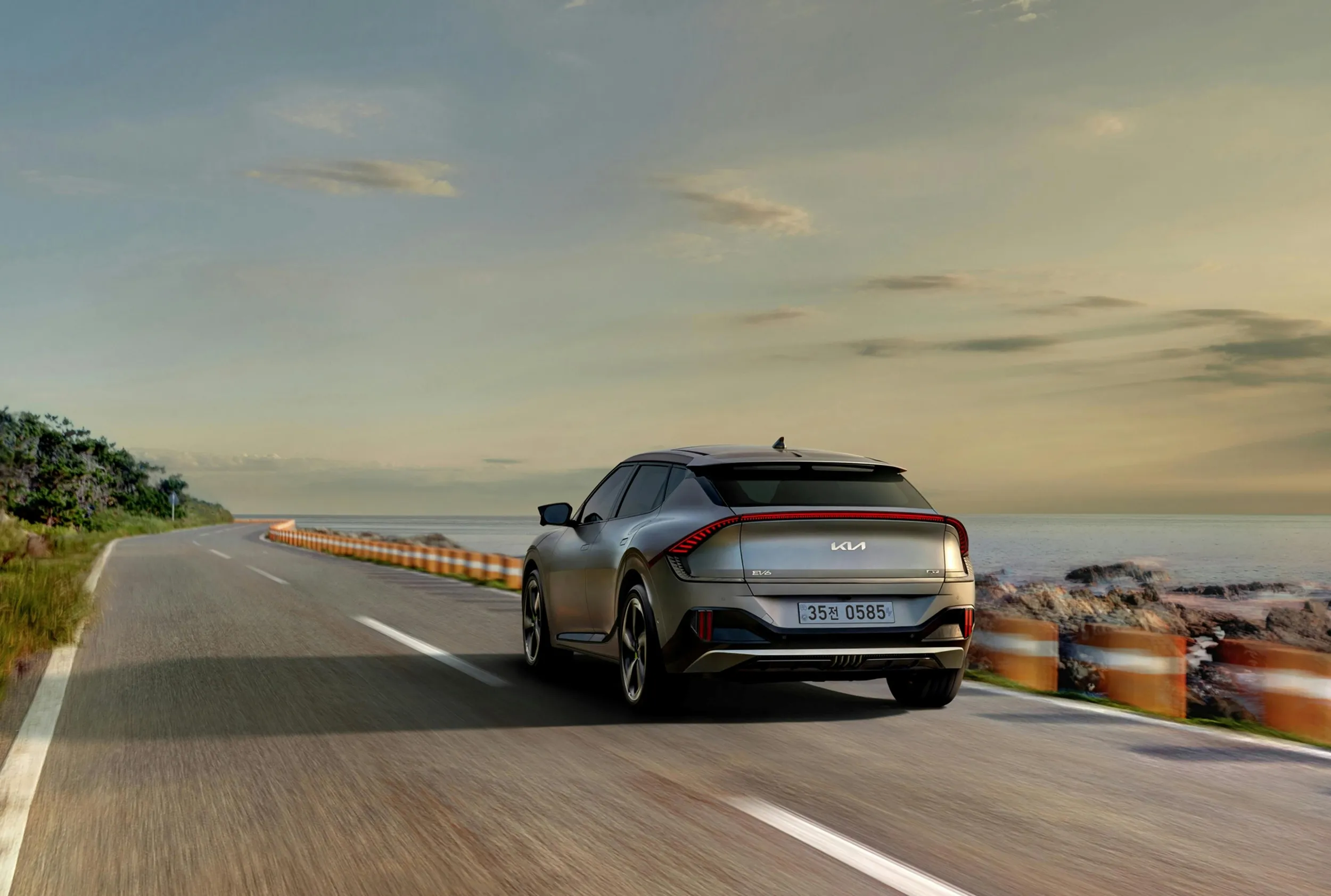 Electric SUV driving on scenic coastal highway at sunset, modern sustainable mobility