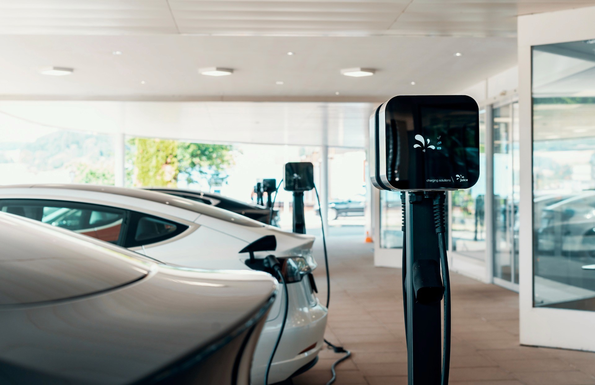 Electric vehicles parked at charging stations in a modern facility, highlighting the development of charging infrastructure to support the growing adoption of electromobility in Switzerland