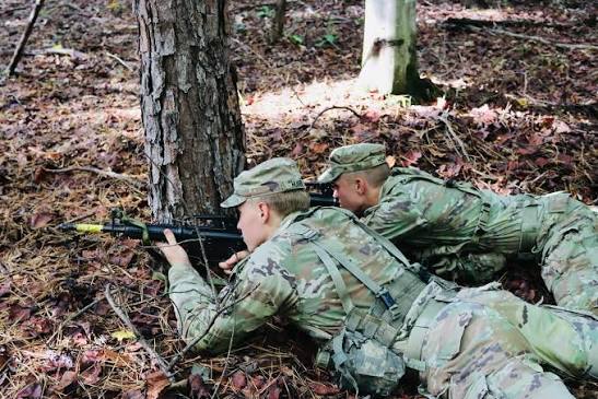 Two Soldiers pulling security in the prone from a woodline objective rally point