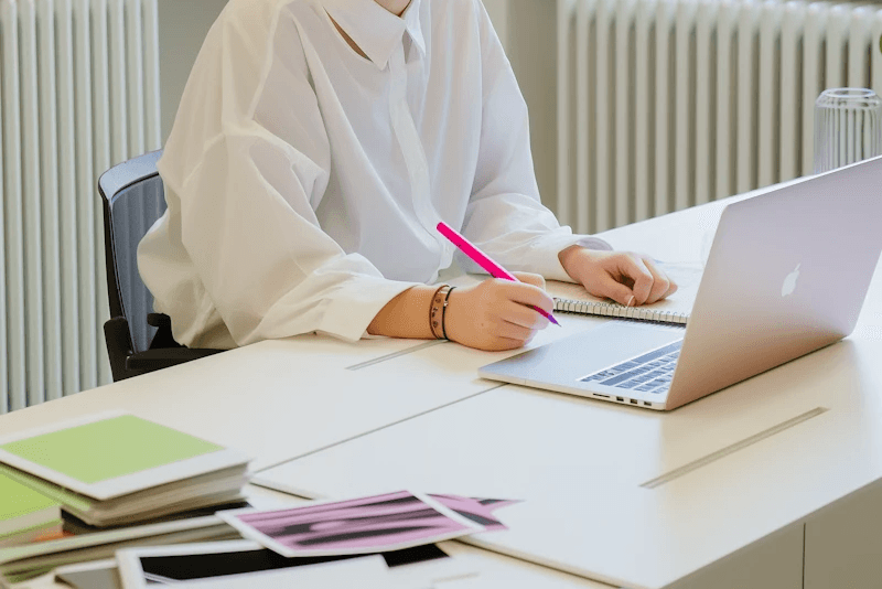 Writing in from of a Macbok in a bright office