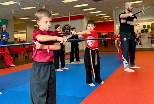 Group of young kid practicing weapon form.