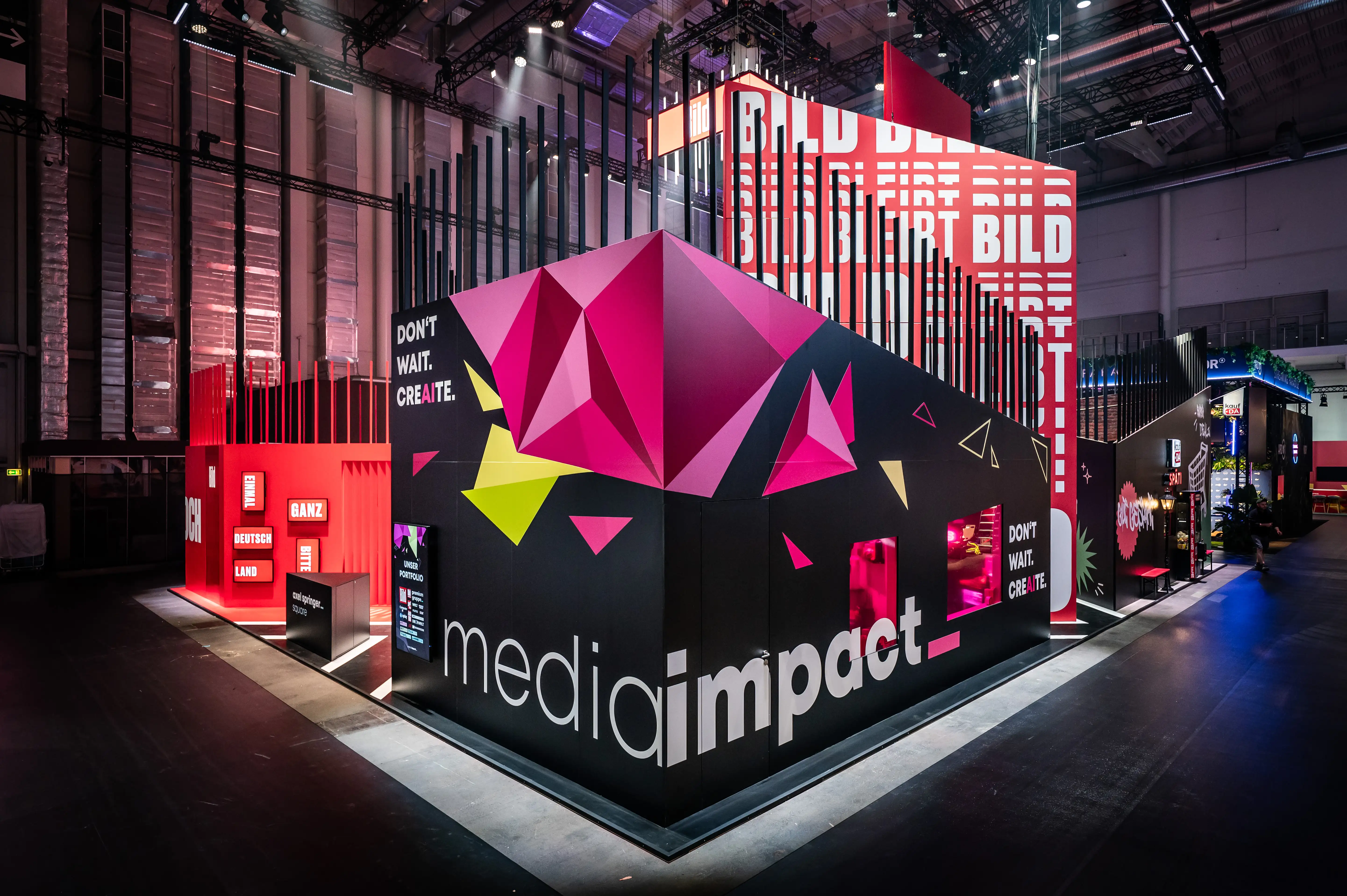 Media Impact cube with pink crystal sculpture on black facade in front of the red Bild booth.
