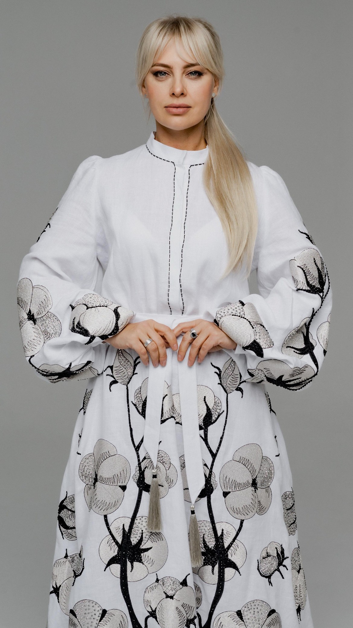Portrait of a red-haired woman wearing layered gold and crimson necklaces