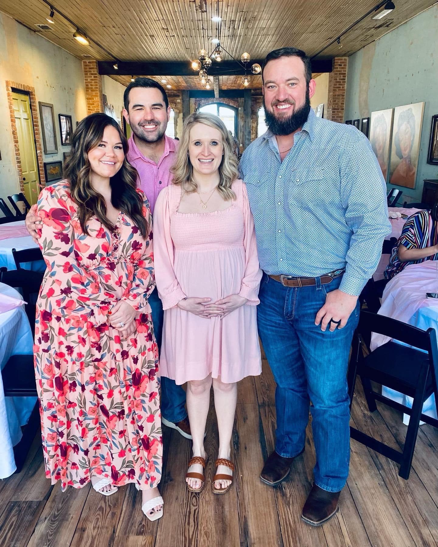 A group of people smiling at the camera at a baby shower taking place at Loose Latigo gallery