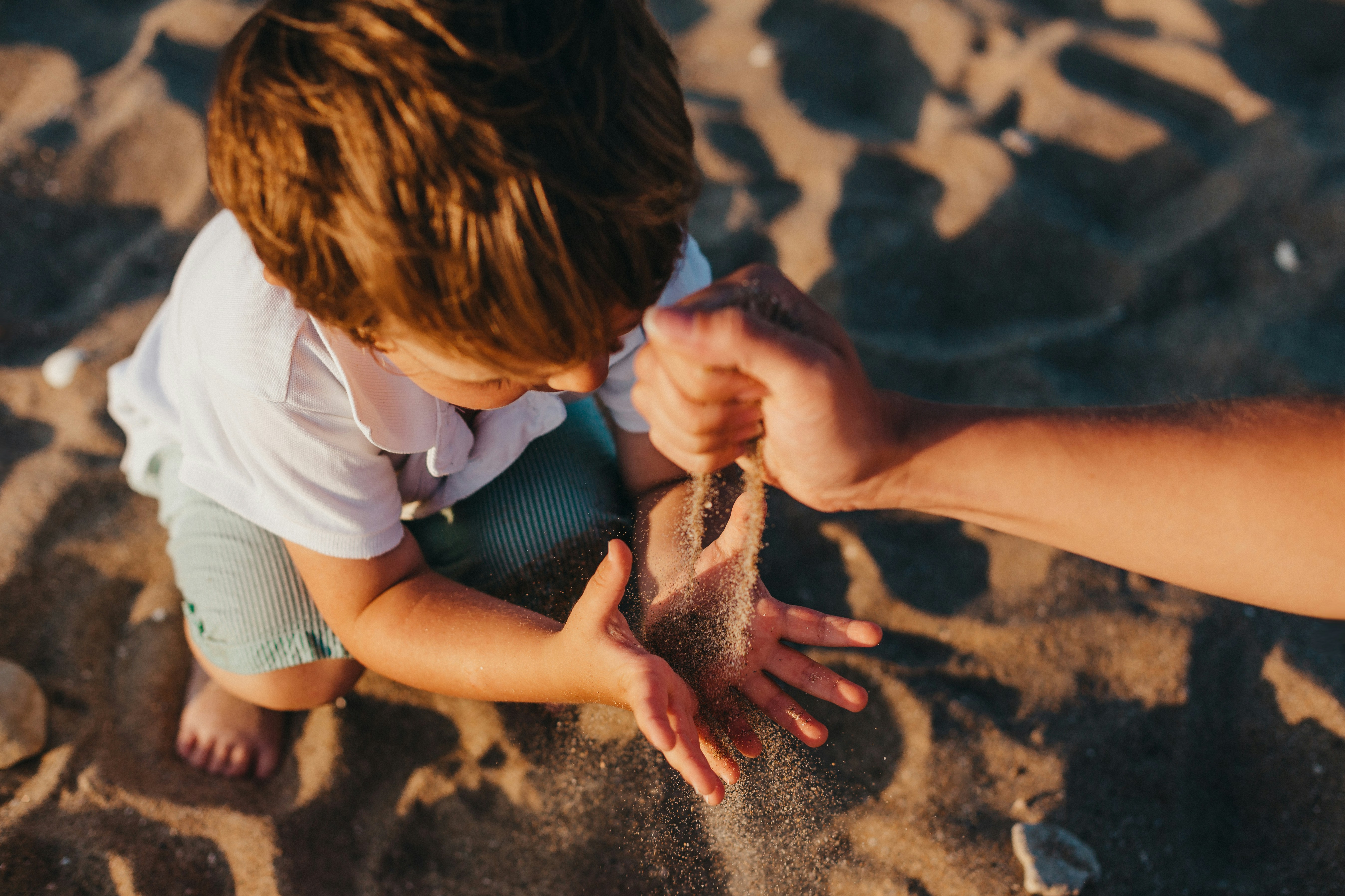 Famille avec un enfant jouant dans le sable