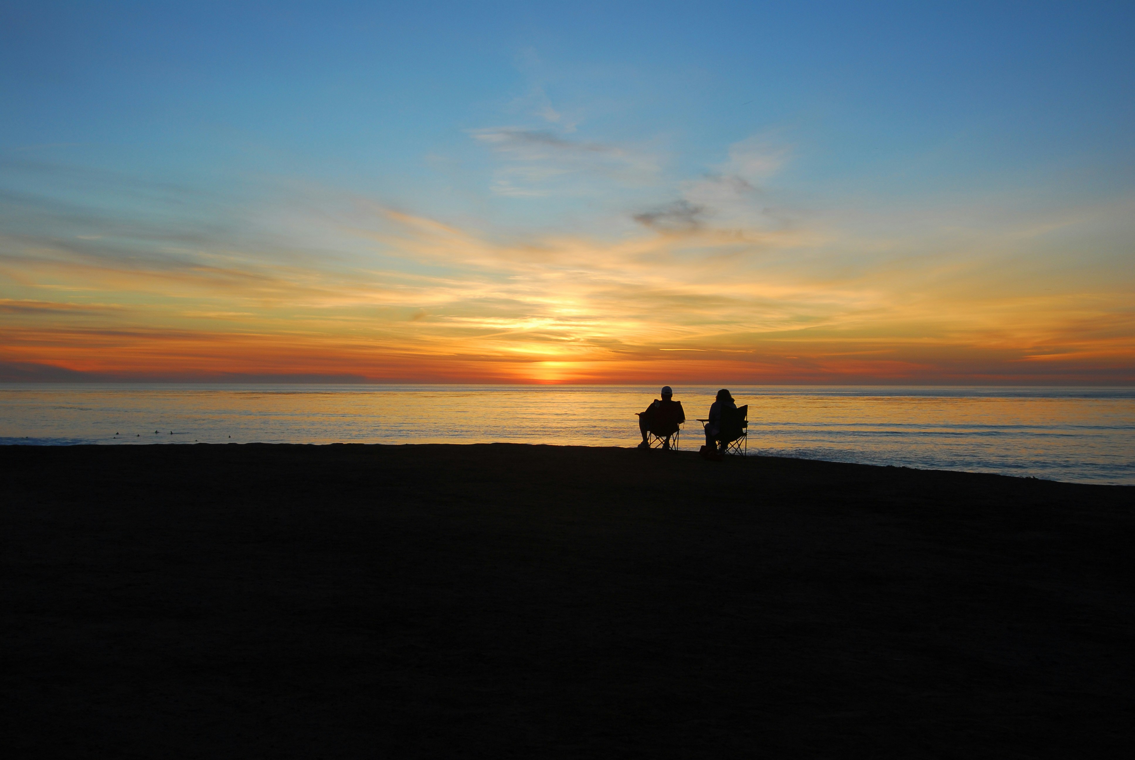 a-couple-of-people-standing-on-top-of-a-beach - greg-bulla (unsplash)./pho