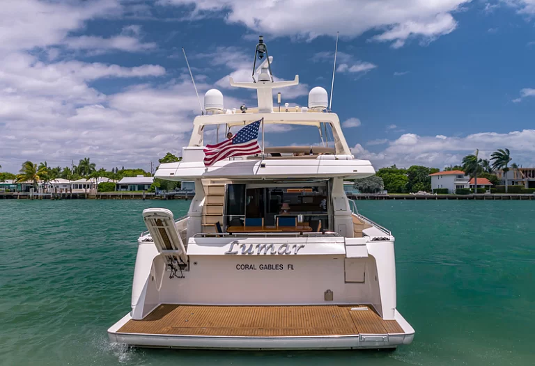 Dining area on the aft deck of the Ferretti Lumar 75ft yacht, set against an ocean backdrop.