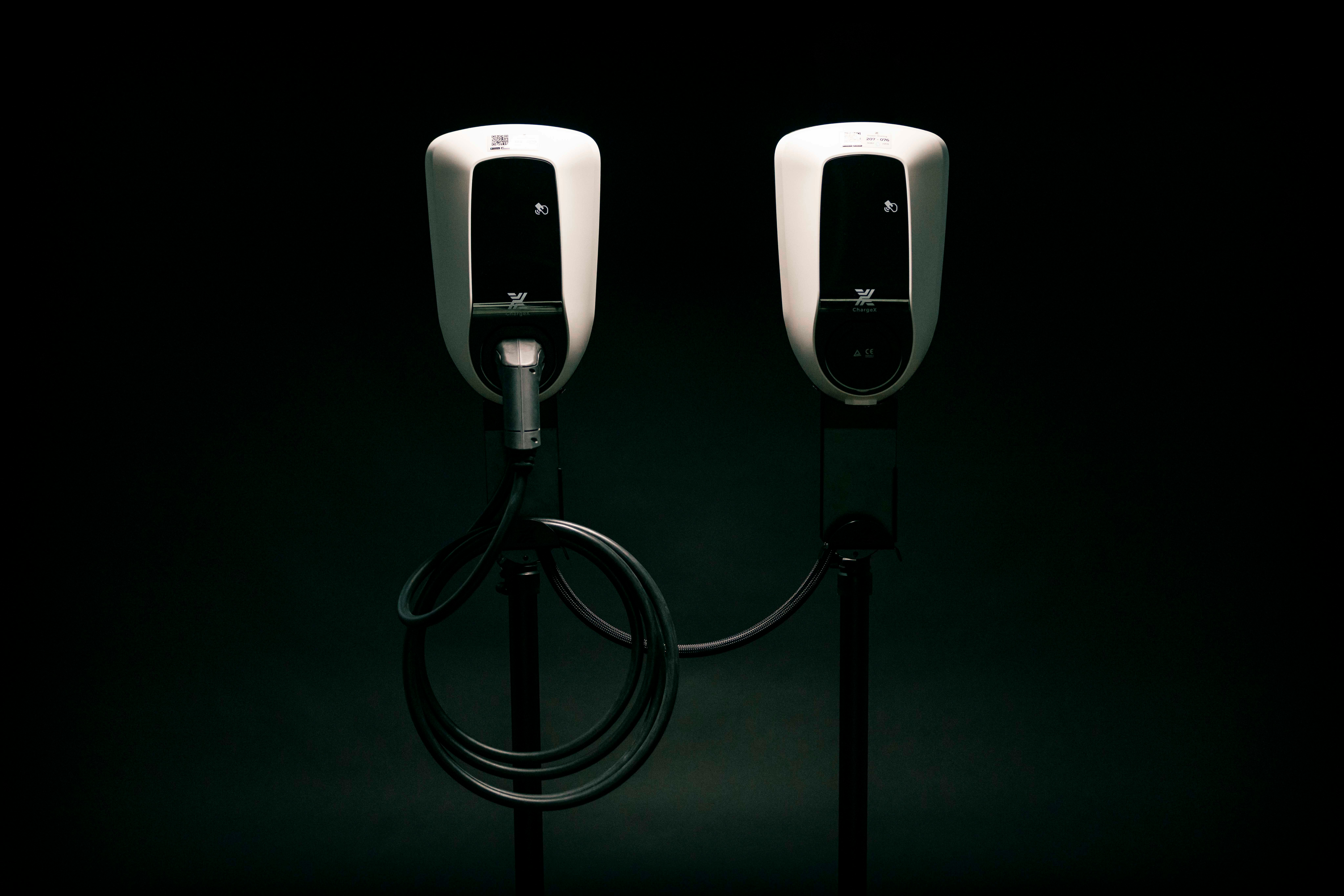 a couple of black and white tesla chargers on a black background