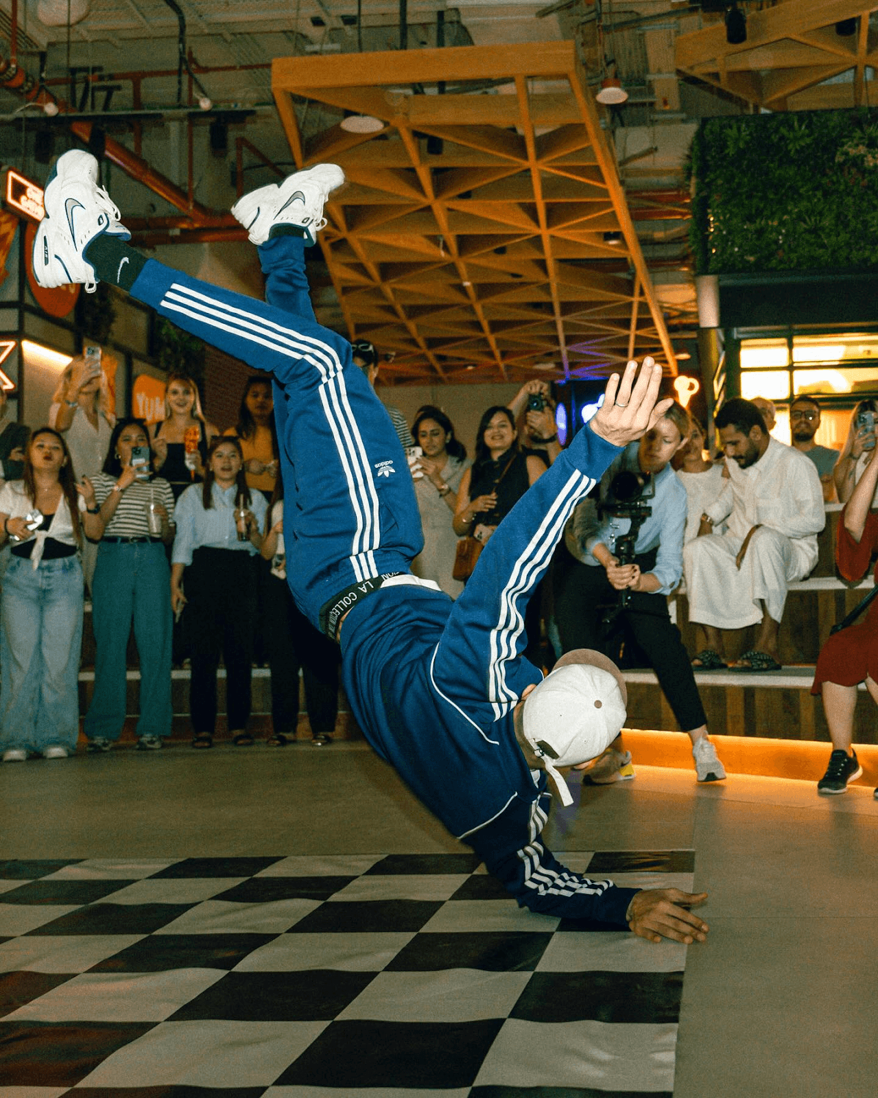 Breakdancer performing in front of guests at a lively social restaurant event.