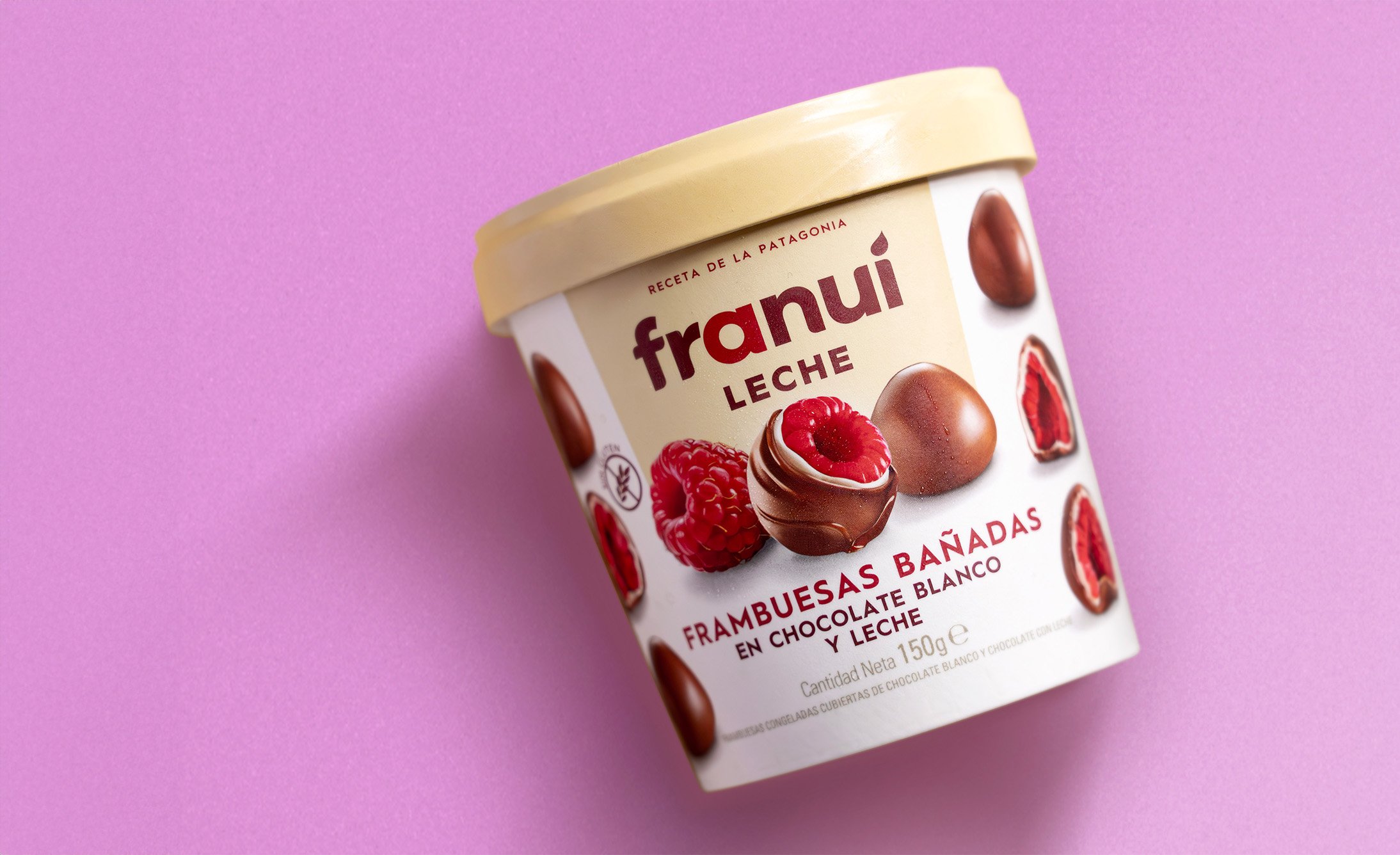 A container of chocolate sweets on a pink background, showcasing its label and design.
