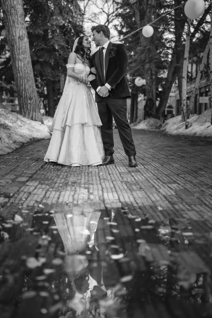 Bride and groom walking snowy path during T-Lazy 7 elopement Aspen black and white