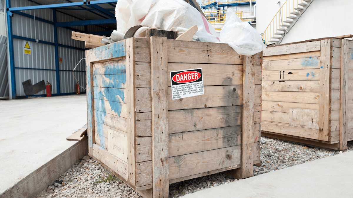 Wooden export crate marked with a red "Danger" label for hazardous waste disposal.