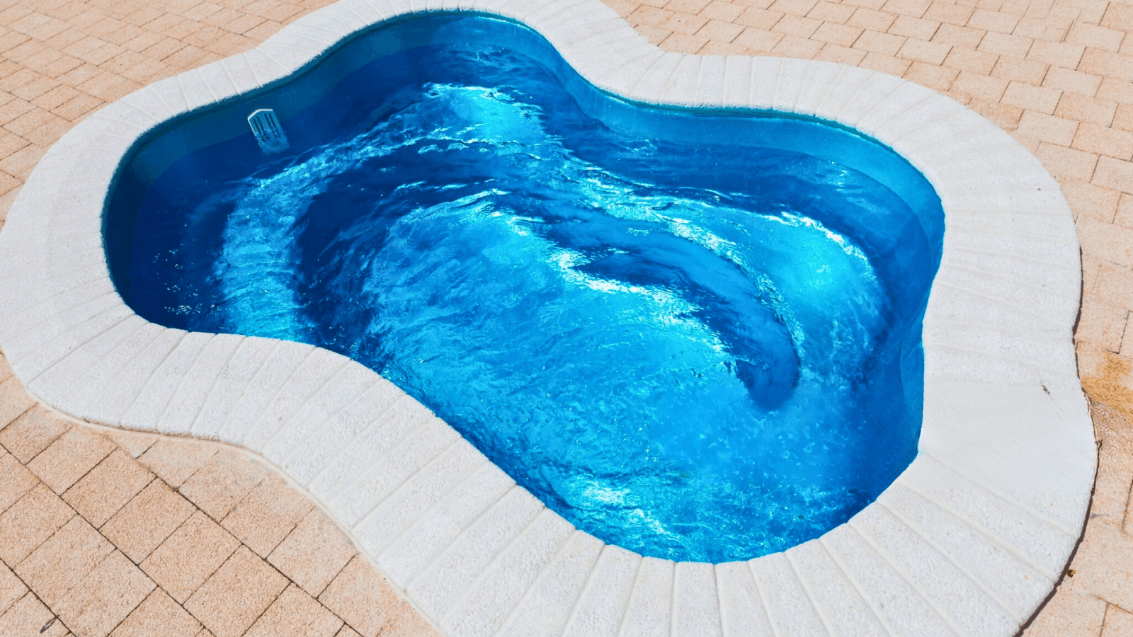 Low-maintenance fiberglass pool installation in Central Ohio with curved design