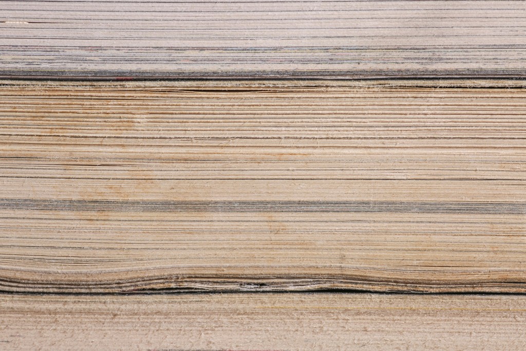 Close-up of aged book pages stacked horizontally