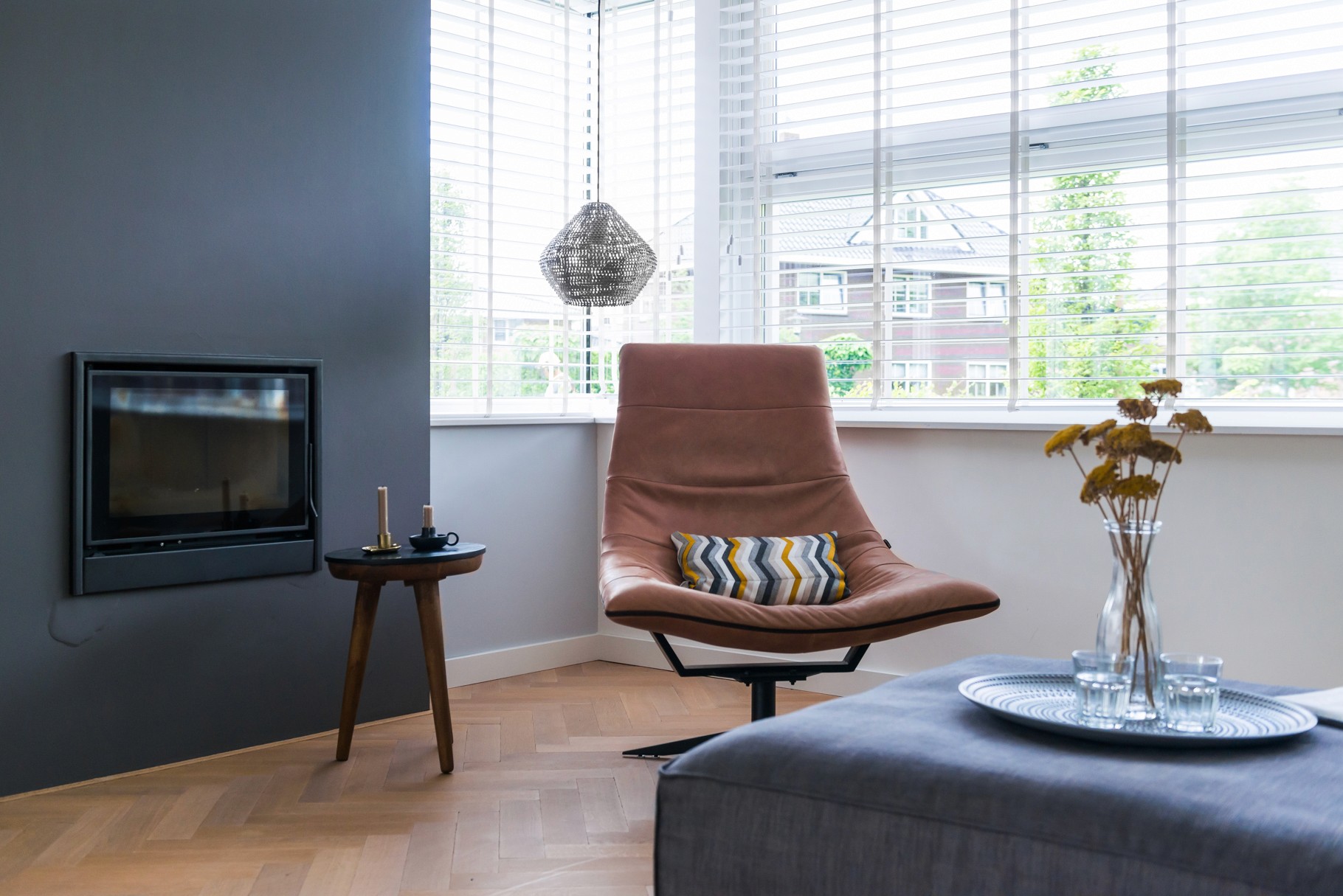 zitje bij de haard in donkere kleuren met cognac leren draaistoel