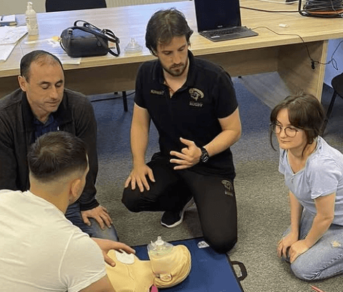 another photo of group of people practicing interventions on a doll