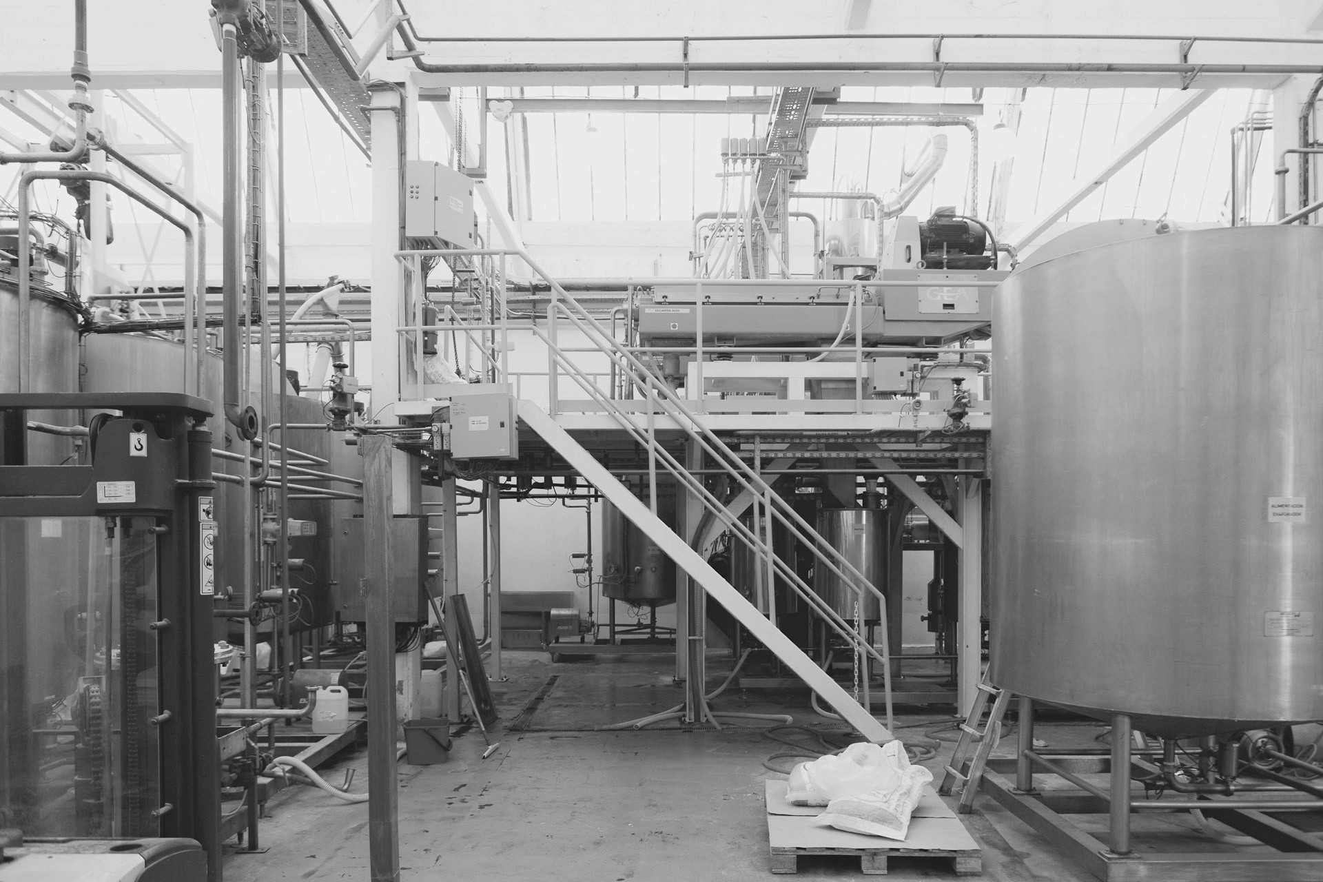 Large stainless steel mixing tanks and equipment inside a food manufacturing facility.