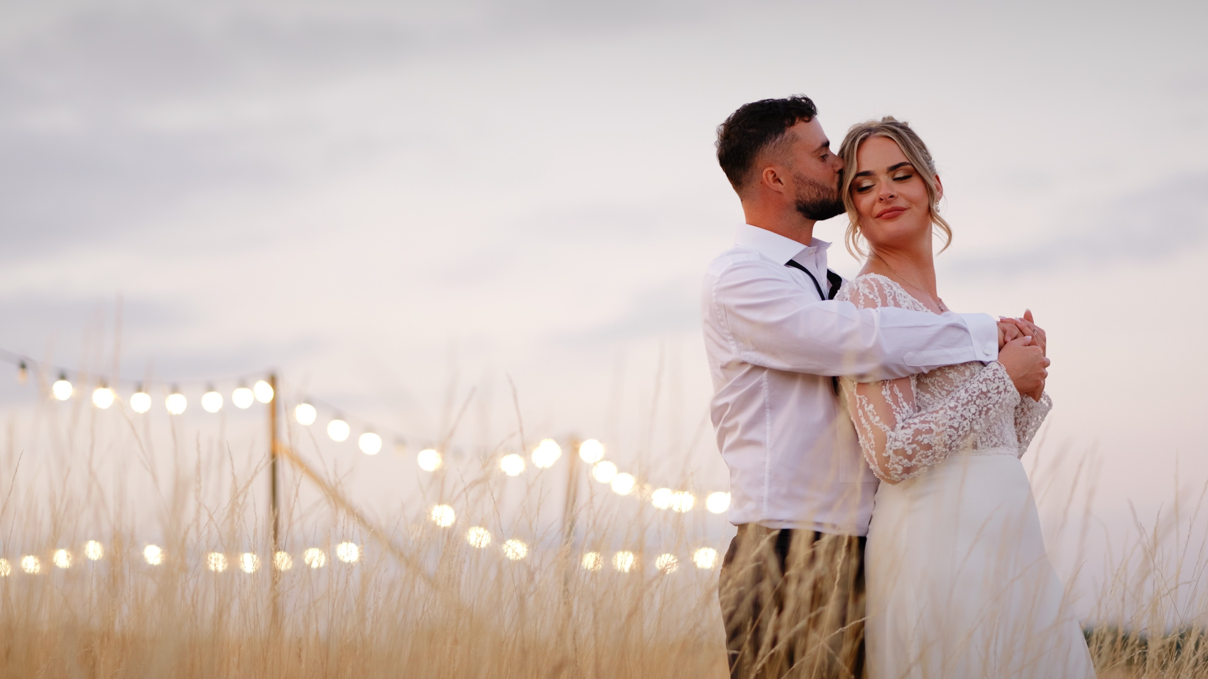 Bride and groom kissing during portraits at Doddington Hall in Lincolnshire, with the historic church and garden walls in the background