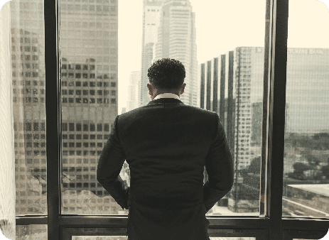 man putting hands on pocket while standing in front of glass wall