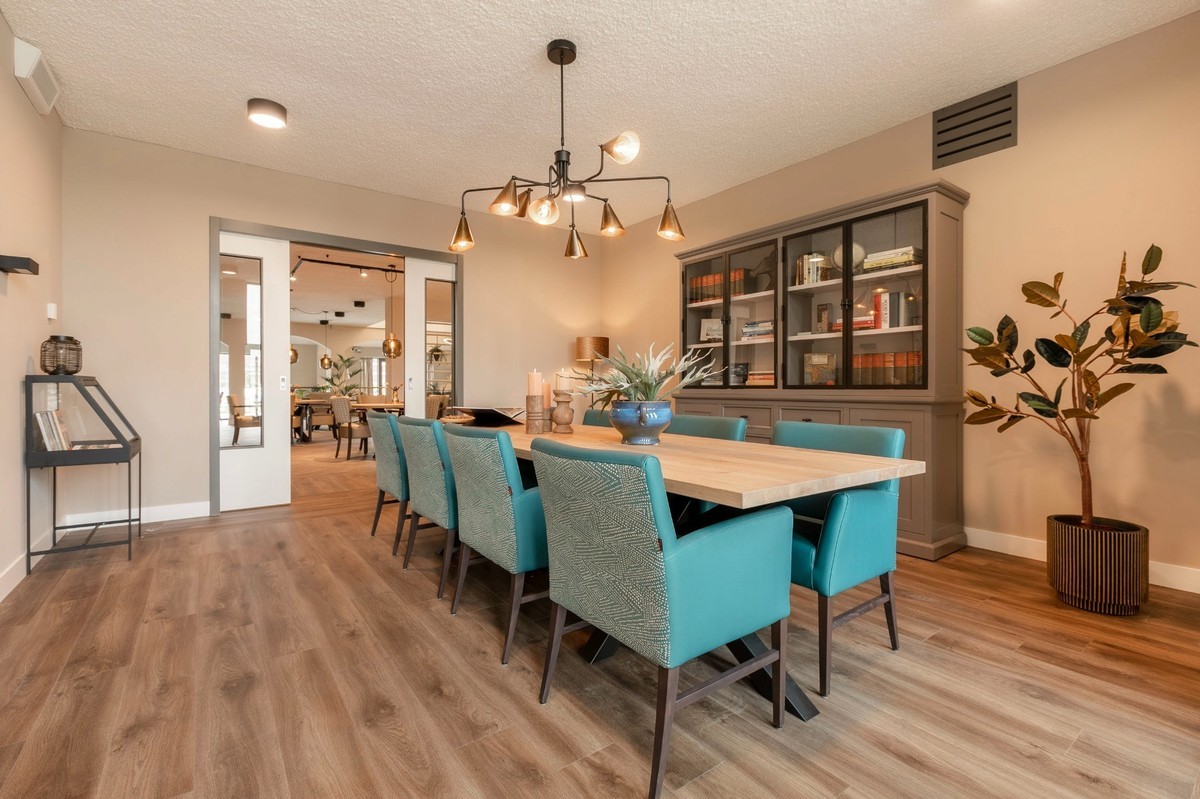 woonkamer blauwe stoelen en grijze boekenkast