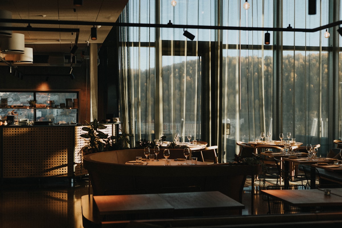 Sala de un restaurante al atardecer, con las mesas montadas y la barra de servicio lista antes del turno
