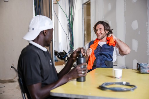 Workers on break using an orange G-Heat cooling towel in a hot environment