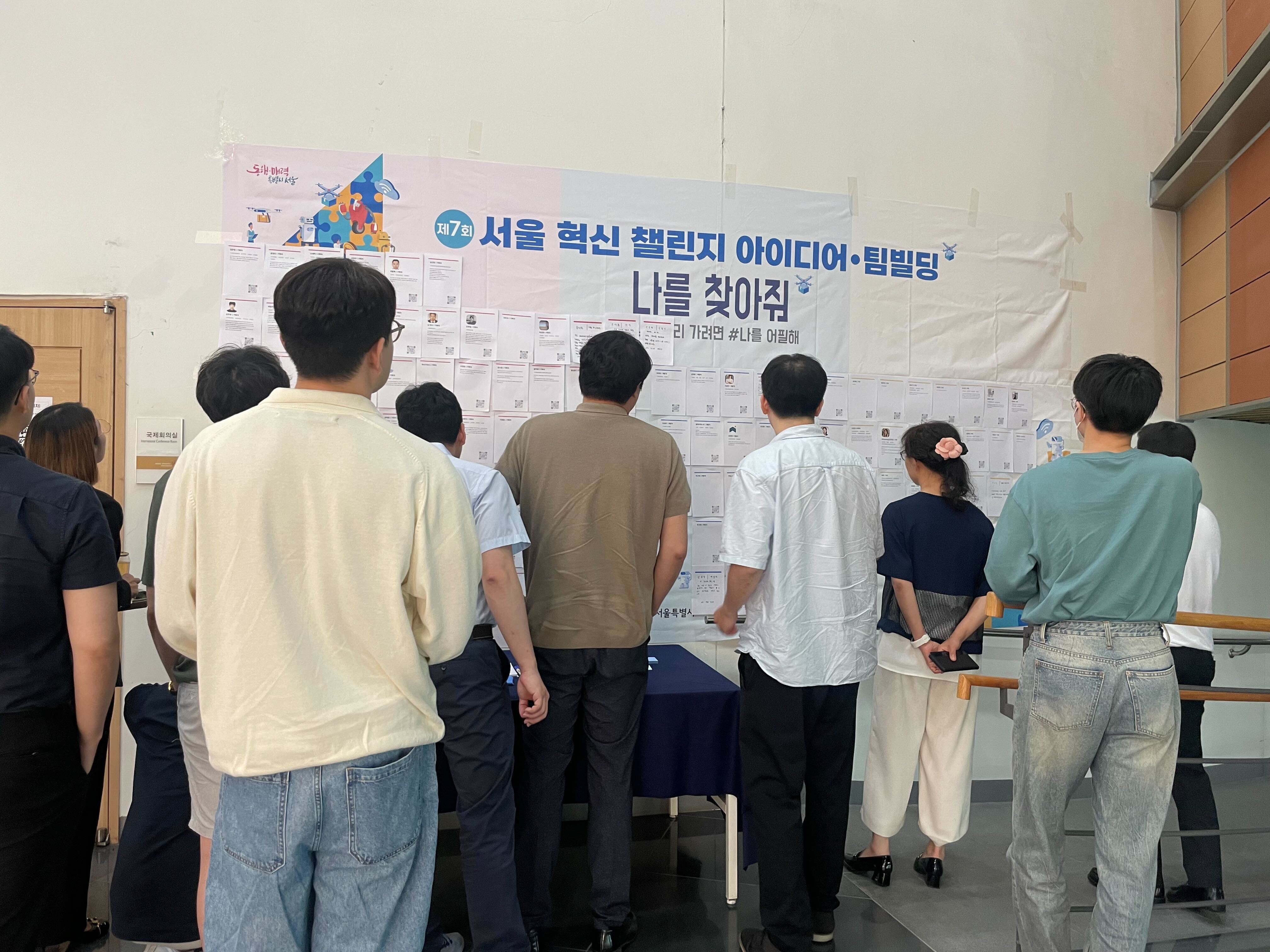 행사장에서 서로의 프로필 카드를 둘러보고 네트워킹에 참여하는 모습