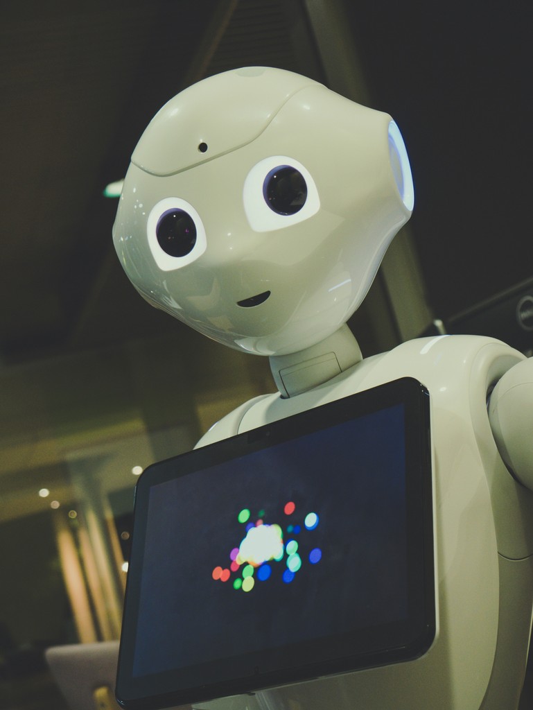 A humanoid robot with large expressive eyes and a built-in screen displaying colorful lights, exemplifying advanced robotics and artificial intelligence technology.