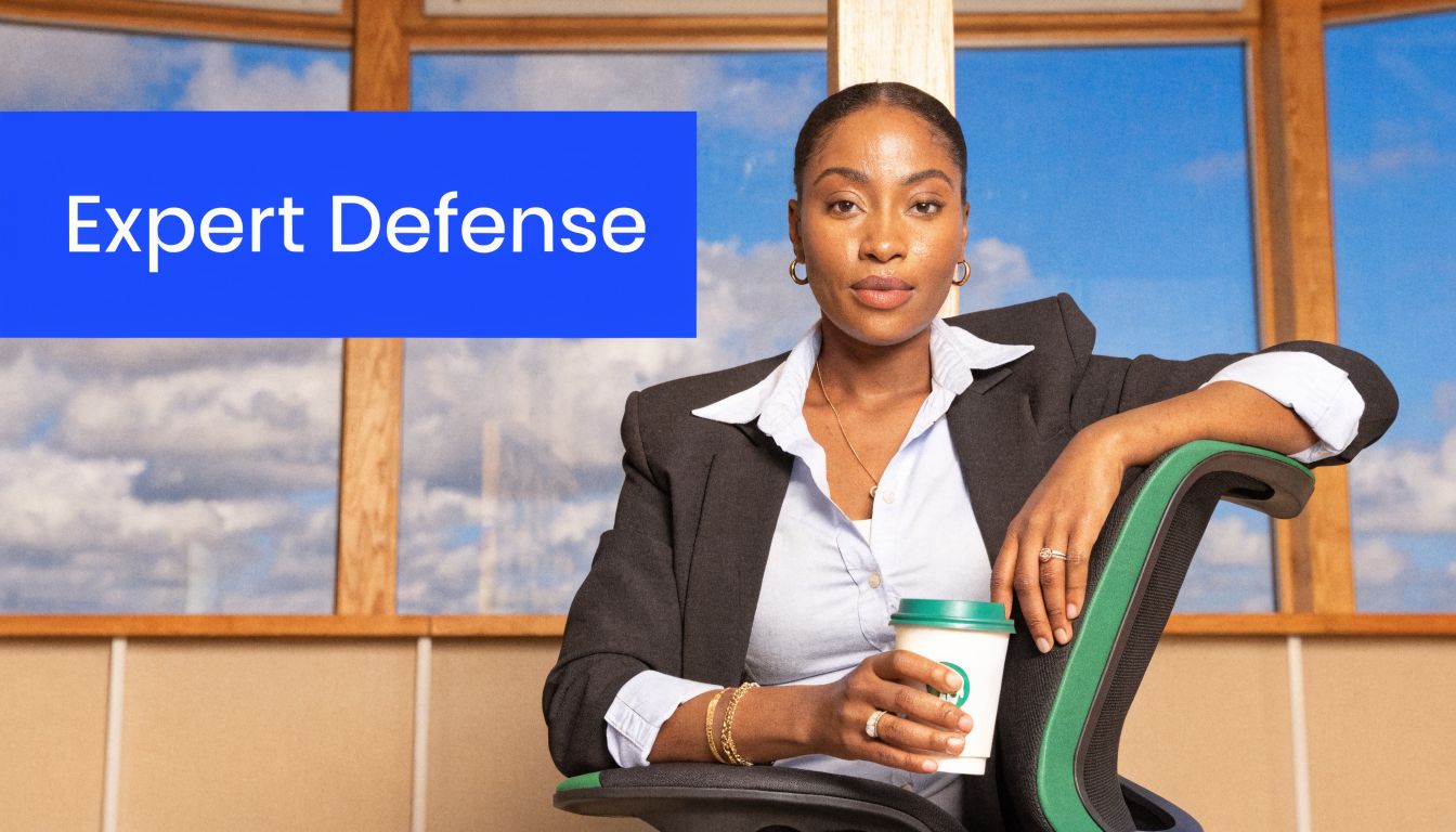 A professional woman in a business suit sitting in an office, holding a coffee cup.