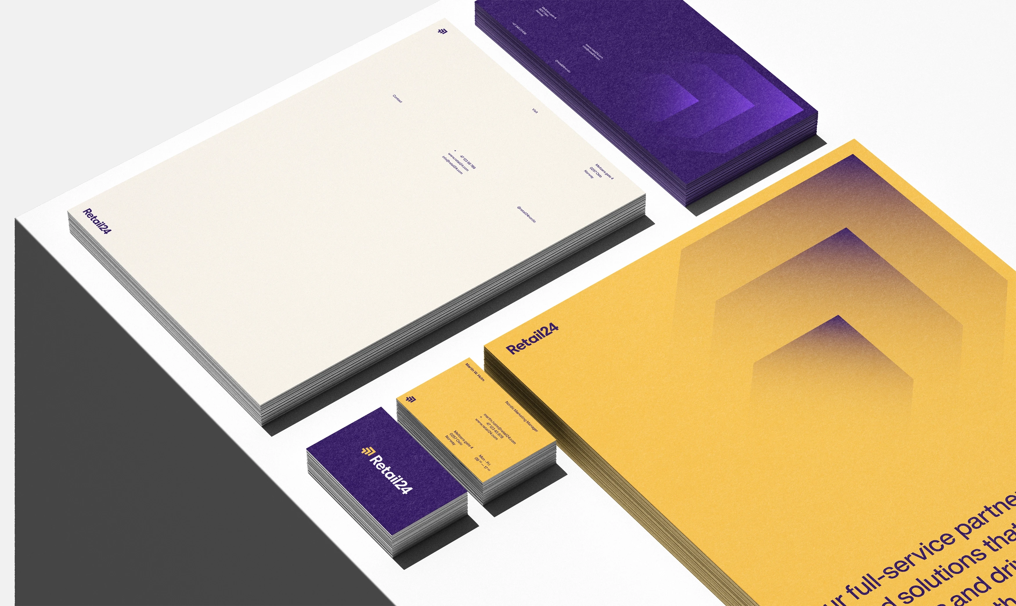 Assortment of professional branding materials including notebooks, business cards, and a pamphlet in a studio setting.
